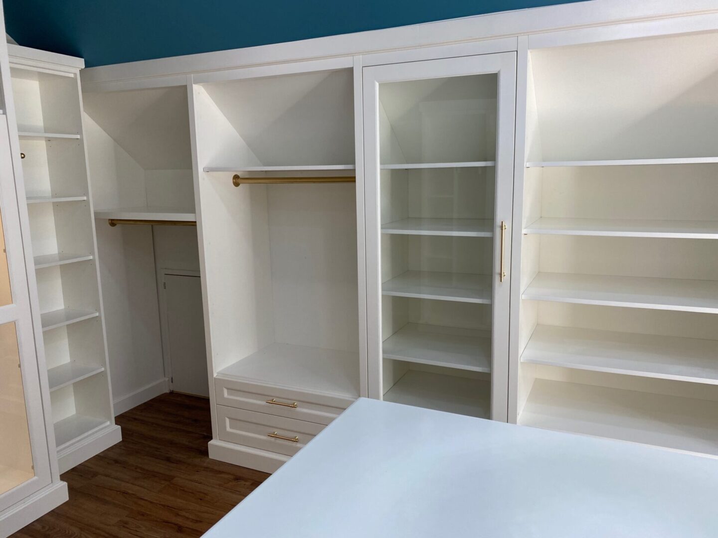 An Empty Closet Space With White Shelves