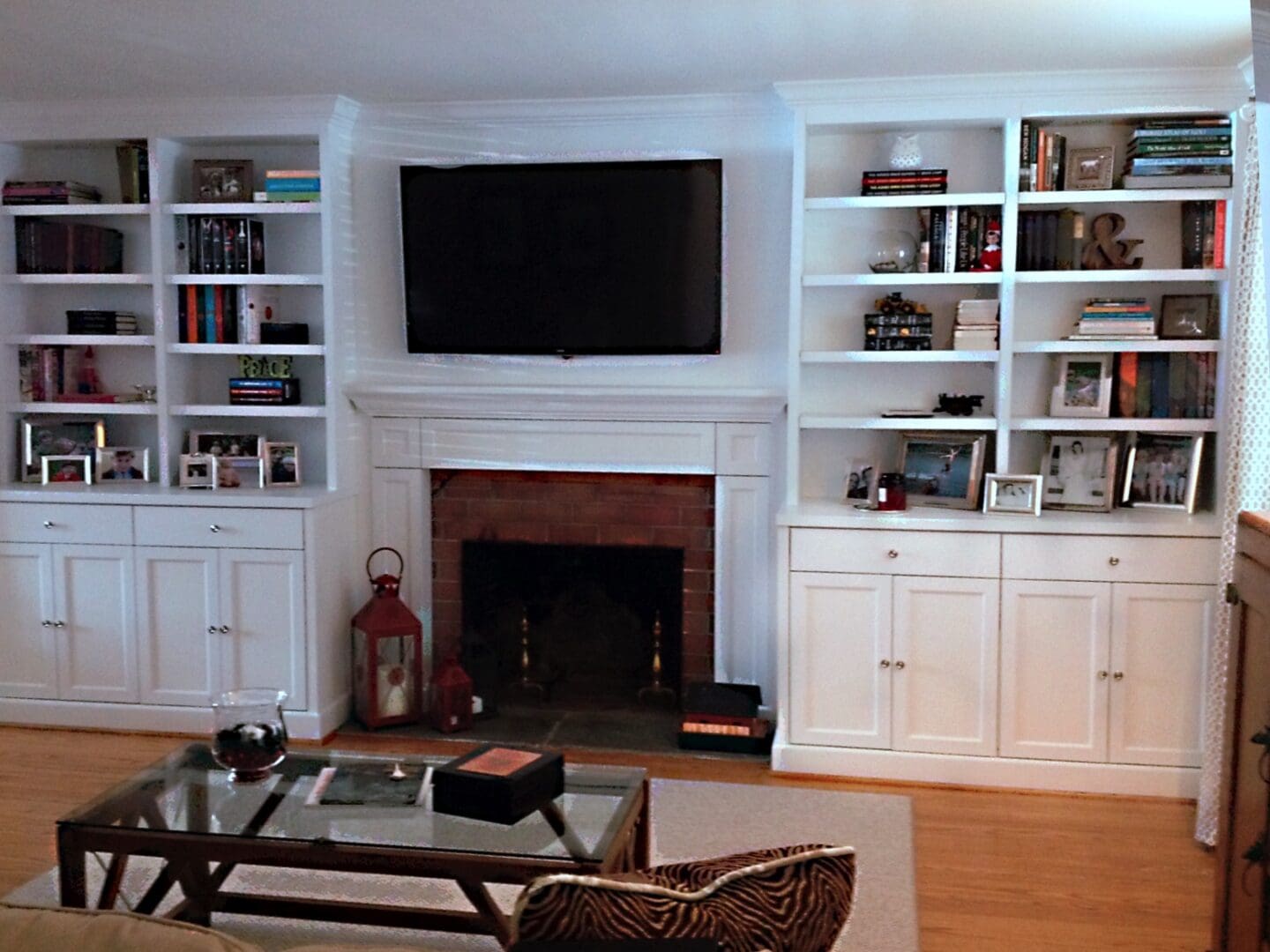 A Flat Screen Above a Fireplace With Bookshelves