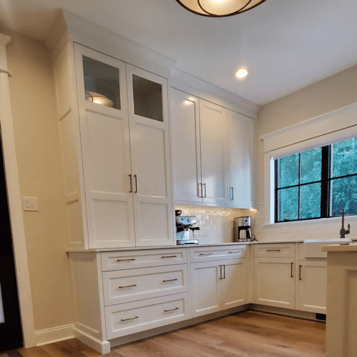 A Kitchen Cabinet Space With White Color Cupboards