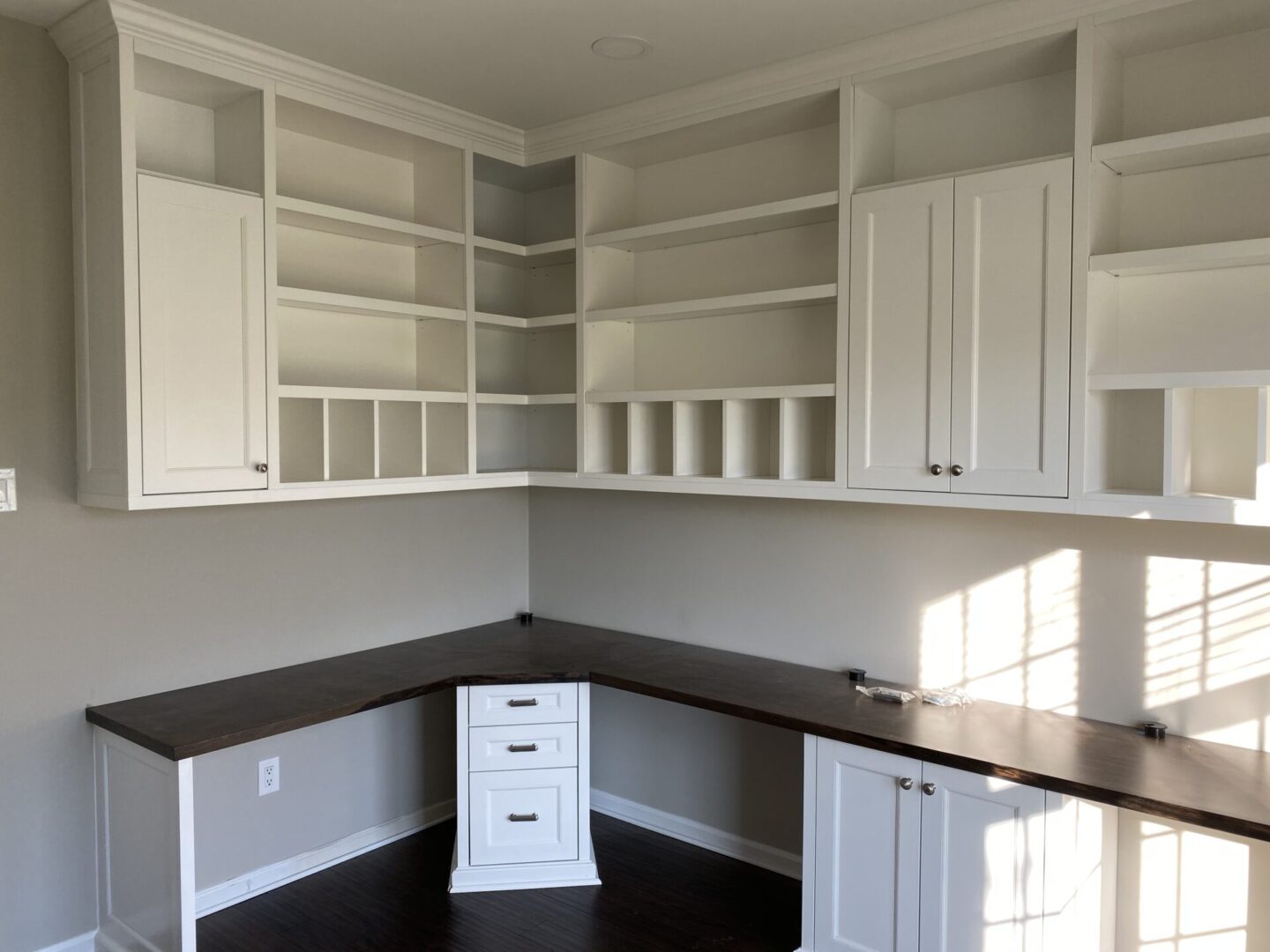 A Shelf Unit Space With a White Cabinets and a Counter