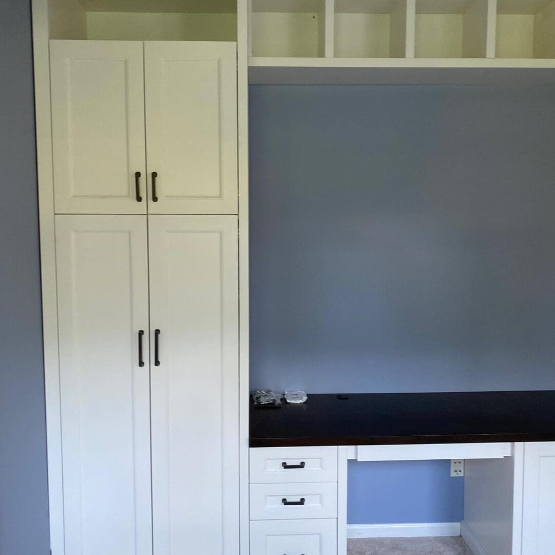 A Long White Color Cabinet Space With Black Handel