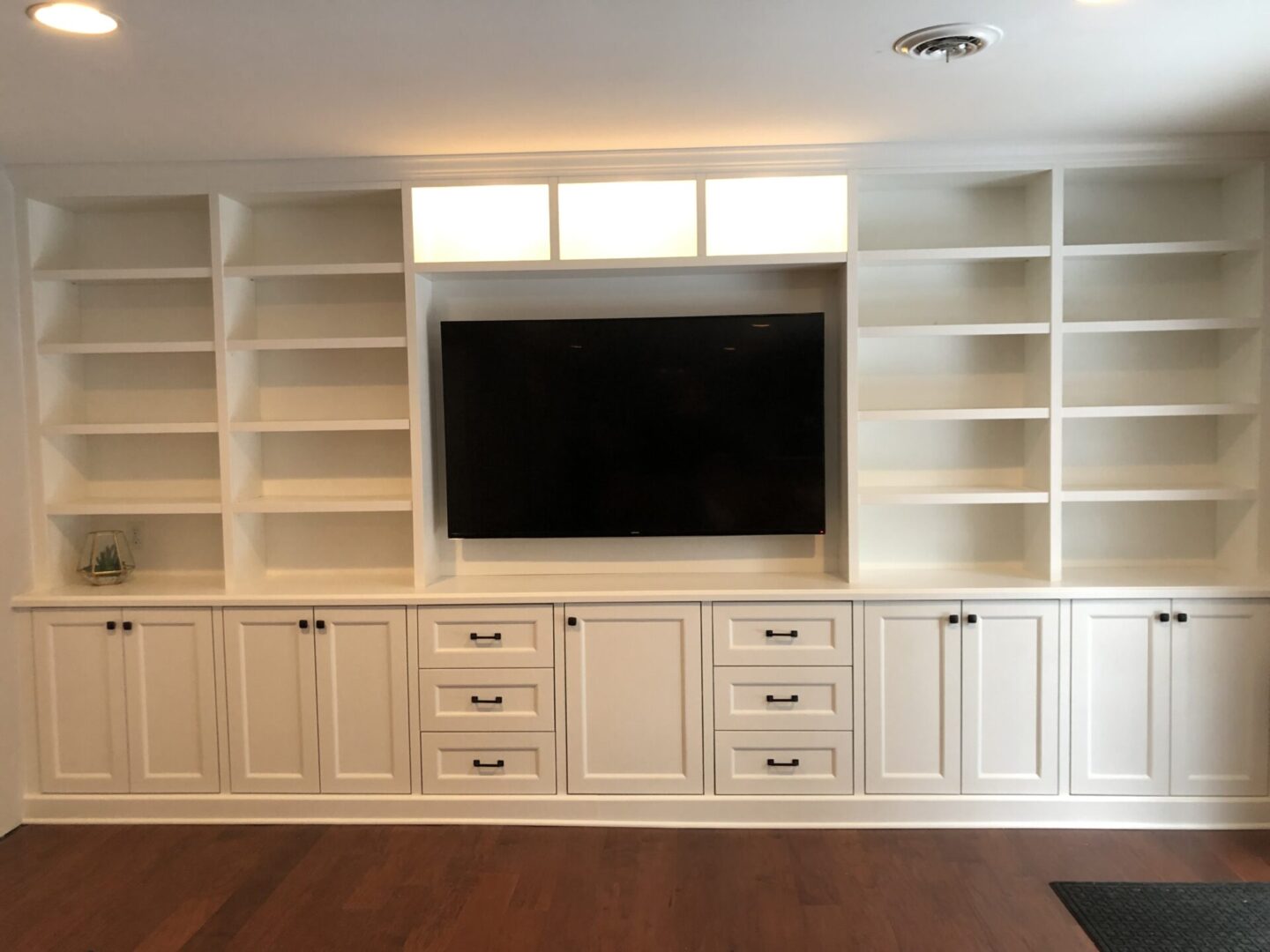 An Entire Television Unit With White Shelves