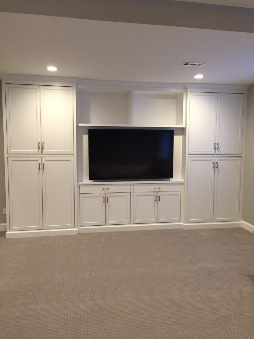 A well cleaned house with a tv in front and all white interiors.