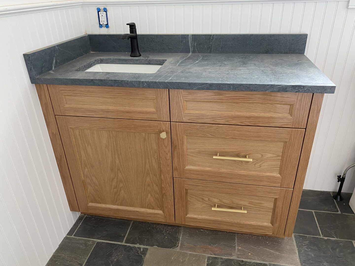 A wooden cabinet with sink on top under cnstruction